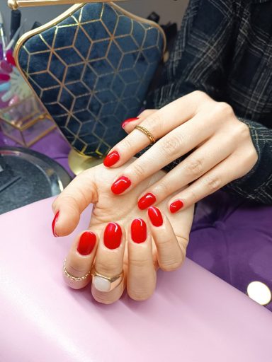 a woman's hands with red painted nails